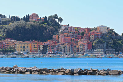 Sea by buildings against clear sky