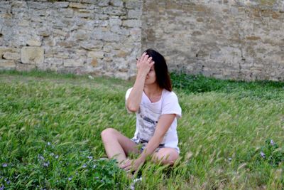 Woman relaxing on grassy field