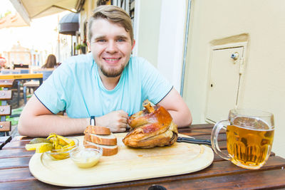 Portrait of smiling man with food on table