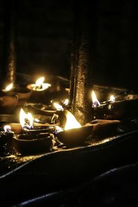 Close-up of lit candles in the dark