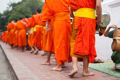 Rear view of people standing on footpath