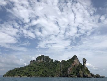 Rock formation by sea against sky