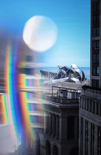 Digital composite image of buildings against clear blue sky