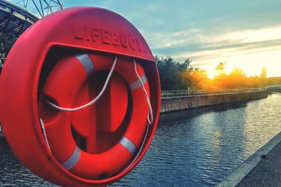 Close-up of red water on river against sky during sunset