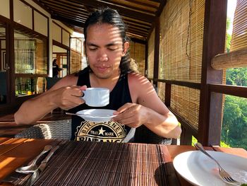 Young woman drinking coffee at restaurant