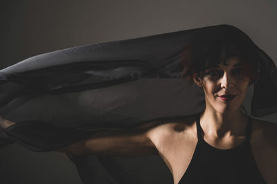 Portrait of young woman against gray background