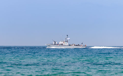 Ship sailing in sea against clear blue sky