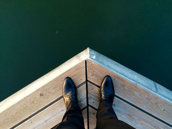 Low section of woman standing in front of lake