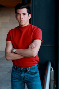 Portrait of young man standing against wall