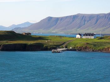 Scenic view of sea and mountains against sky