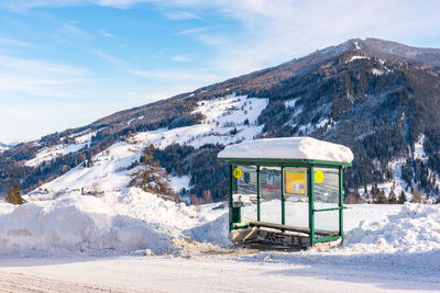 Ski bus stop at austria. scenic view of snowcapped mountains against sky. 