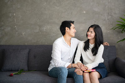 Young couple sitting in corridor