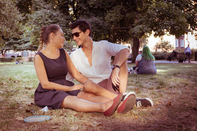 Friends sitting on field in park