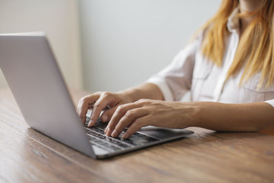 Hands of businesswoman working on laptop at desk in the office