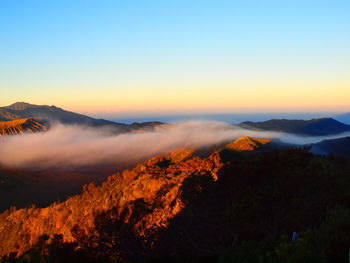 Scenic view of mountains against orange sky