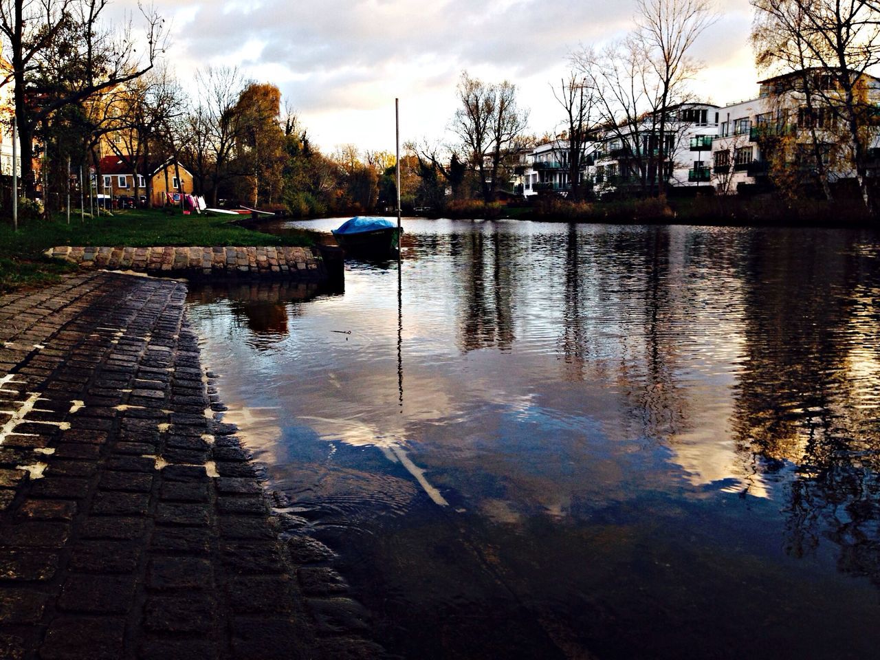 water, sky, building exterior, tree, reflection, built structure, architecture, cloud - sky, lake, cloud, river, transportation, bare tree, canal, tranquility, tranquil scene, nature, outdoors, waterfront, sunset