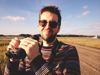 Man wearing sunglasses at beach against sky