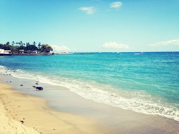 Scenic view of beach against blue sky