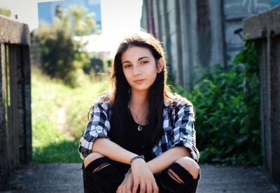 Portrait of beautiful young woman sitting outdoors