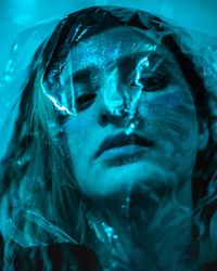 Close-up portrait of woman seen through plastic