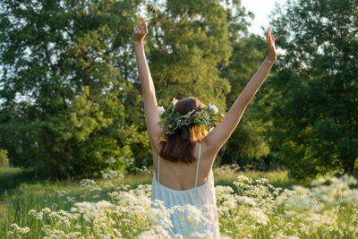 Rear view of woman wearing wreath amidst flowers