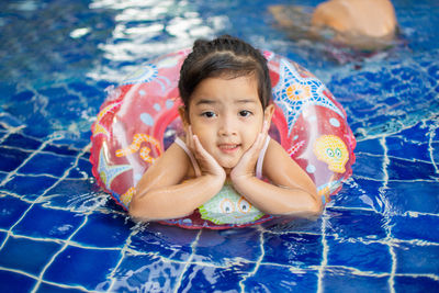 Portrait of cute girl with inflatable in swimming pool