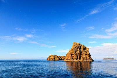 Scenic view of rock formation in sea against sky