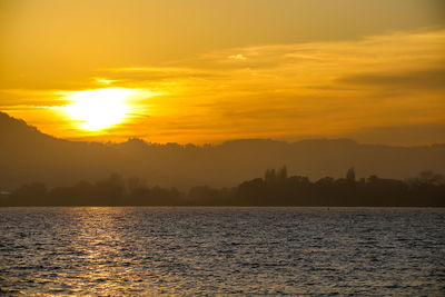 Scenic view of sea against orange sky