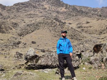 Full length of young man standing on rock