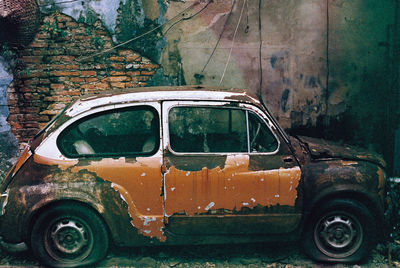 Abandoned car against building