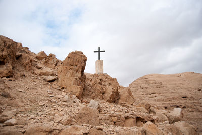 Low angle view of cross on building against sky