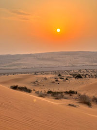 Scenic view of desert against sky during sunset