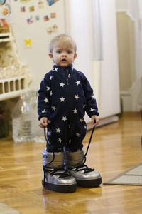 Cute boy standing on hardwood floor