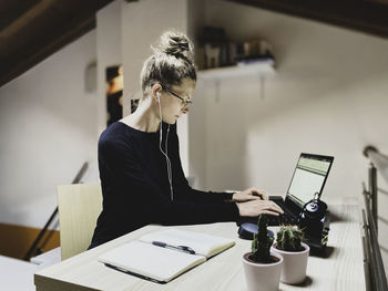 Woman using laptop while working at desk