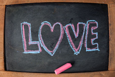 Close-up of love text on blackboard