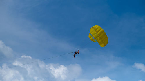 Low angle view of person paragliding against sky