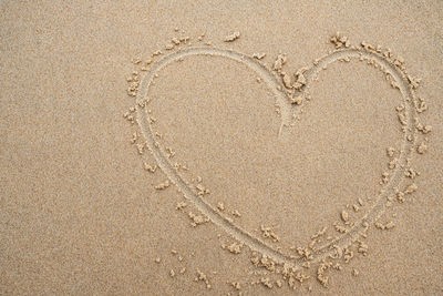 High angle view of heart shape on sand