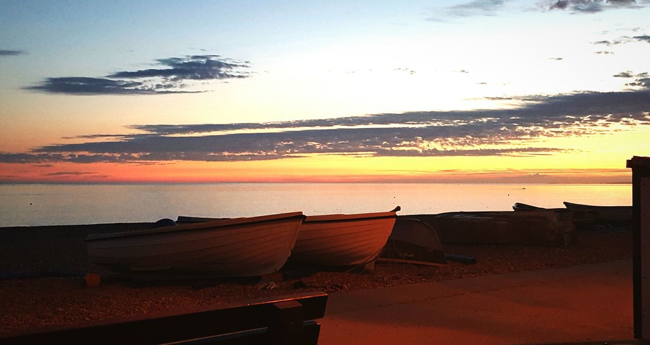 sea, water, sunset, sky, scenics, tranquil scene, tranquility, built structure, horizon over water, building exterior, beach, nature, beauty in nature, architecture, outdoors, high angle view, dusk, nautical vessel, shore, roof