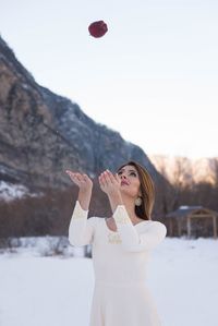 Young woman standing on snow covered mountain