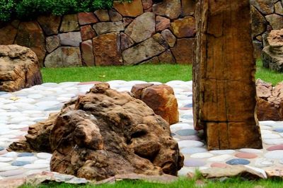 Rocks on grass against trees