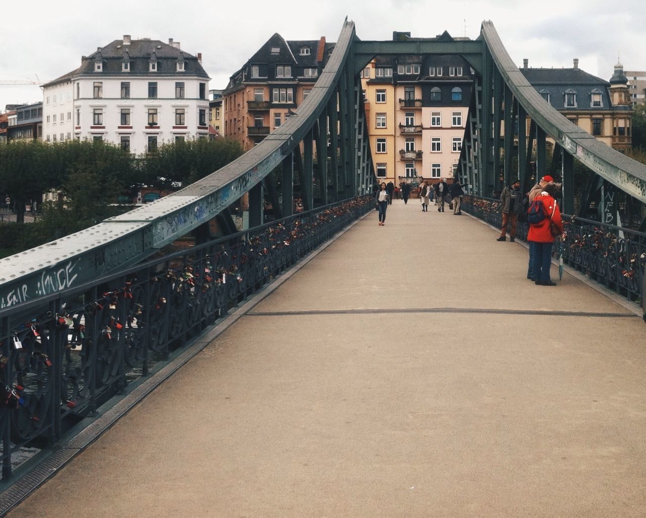 architecture, building exterior, built structure, city, large group of people, men, person, walking, city life, residential building, building, lifestyles, railing, residential structure, sky, leisure activity, street, the way forward, incidental people