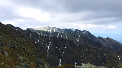 Scenic view of mountains against cloudy sky