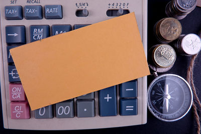 High angle view of coins and paper with calculator on table