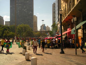 People on street against buildings in city