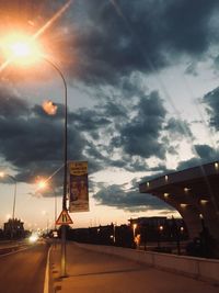 View of city street against cloudy sky