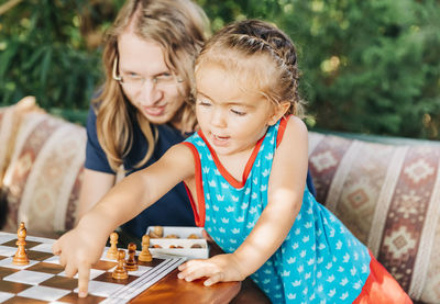 Side view of a smiling girl playing on table