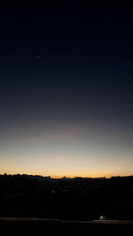 Silhouette landscape against sky at night