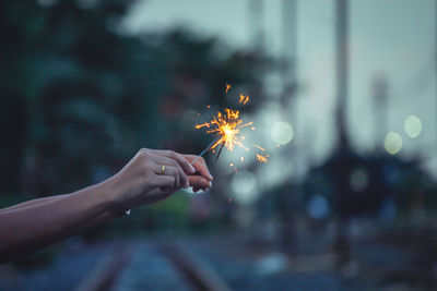 Hand holding sparkler at night