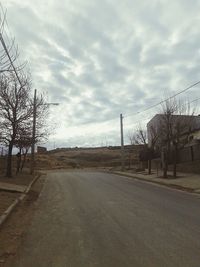 Empty road against cloudy sky