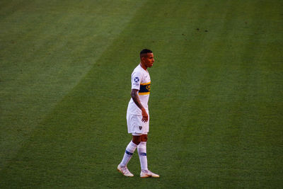 Full length side view of a man standing on grassland